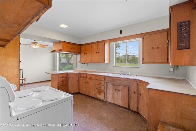 224 S Grace St, Lansing, MI 48917 - kitchen featuring white electric range oven, a sink, brown cabinetry, and plenty of natural light