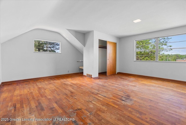 224 S Grace St, Lansing, MI 48917 - unfurnished bedroom with wood finished floors, baseboards, lofted ceiling, and a closet