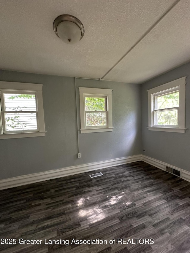 312 Jones St, Lansing, MI 48912 - unfurnished room featuring a textured ceiling, plenty of natural light, dark wood finished floors, and baseboards