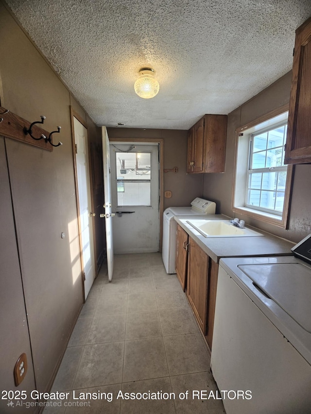 1279 Leland Rd, Ovid, MI 48866 - laundry area featuring cabinet space, washing machine and dryer, a textured ceiling, and light tile patterned flooring