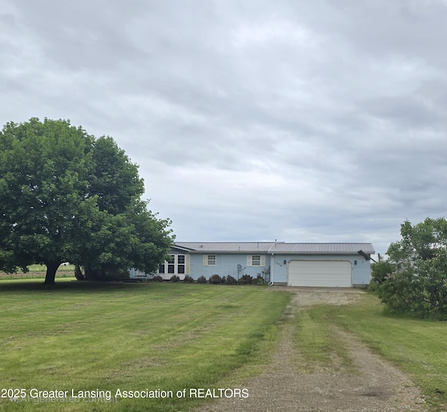 1279 Leland Rd, Ovid, MI 48866 - ranch-style house featuring dirt driveway, an attached garage, a front yard, and metal roof