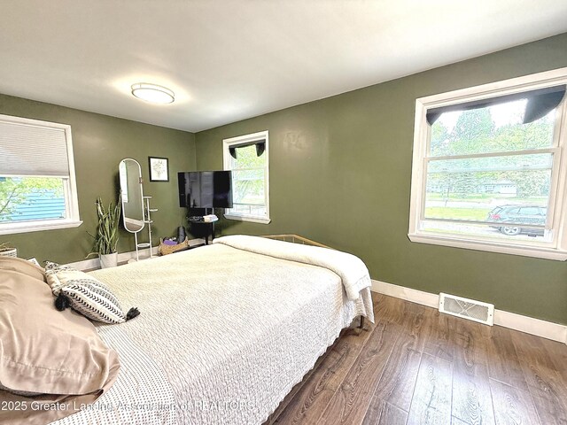 2215 Haslett Rd, East Lansing, MI 48823 - bedroom featuring multiple windows, baseboards, and dark wood finished floors