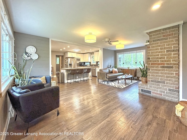 2215 Haslett Rd, East Lansing, MI 48823 - living area featuring healthy amount of natural light, wood finished floors, ceiling fan, and wood walls