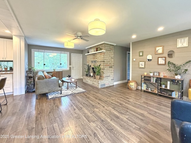 2215 Haslett Rd, East Lansing, MI 48823 - living room featuring ceiling fan, wood finished floors, a brick fireplace, recessed lighting, and baseboards