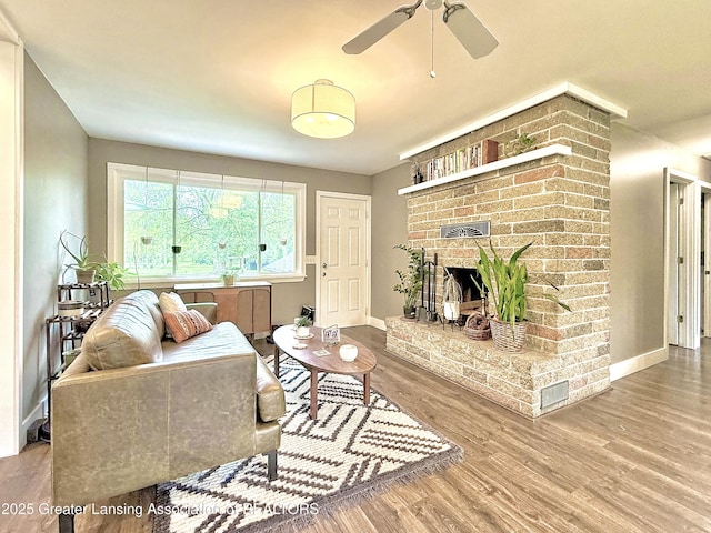 2215 Haslett Rd, East Lansing, MI 48823 - living area with wood finished floors, ceiling fan, a fireplace, and baseboards