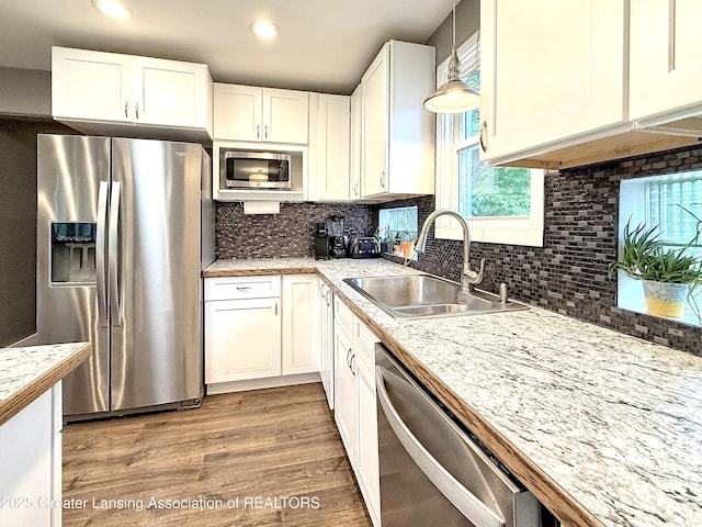 2215 Haslett Rd, East Lansing, MI 48823 - kitchen featuring stainless steel appliances, a sink, light countertops, white cabinets, and recessed lighting