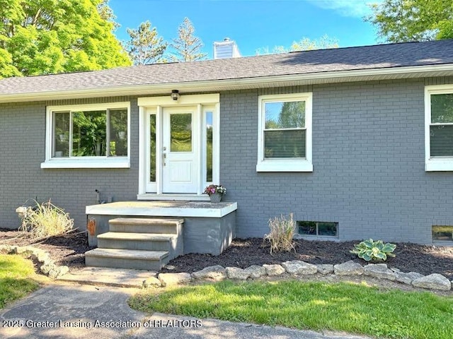 2215 Haslett Rd, East Lansing, MI 48823 - view of front of house with brick siding and a chimney