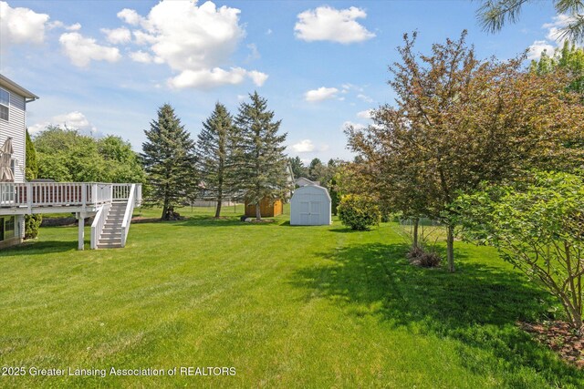 3795 Kirkland Ridge Dr, Holt, MI 48842 - view of green lawn with a storage shed, stairway, a wooden deck, and an outdoor structure