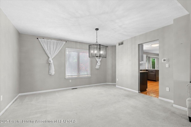 5859 Printemp Dr, East Lansing, MI 48823 - unfurnished dining area featuring light carpet, a chandelier, baseboards, and a textured ceiling
