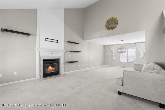 5859 Printemp Dr, East Lansing, MI 48823 - carpeted living area with a chandelier, a towering ceiling, a tiled fireplace, and baseboards