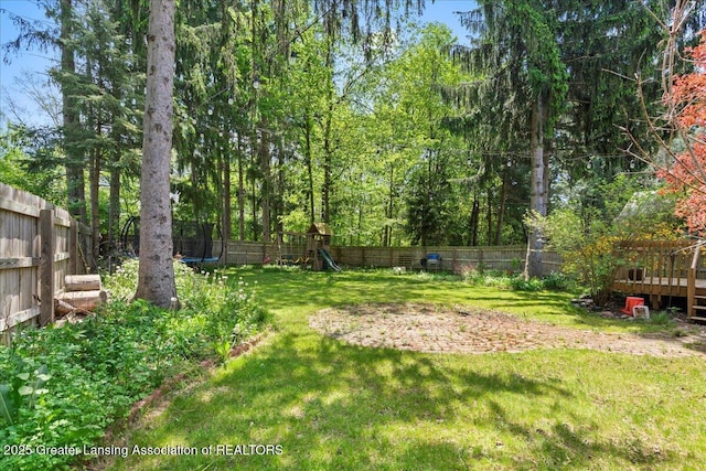 5859 Printemp Dr, East Lansing, MI 48823 - view of yard with a playground, a trampoline, and a wooden deck