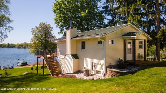 6391 Lakeshore Dr, Lakeview, MI 48850 - rear view of property with a chimney, a yard, a deck with water view, metal roof, and stairway