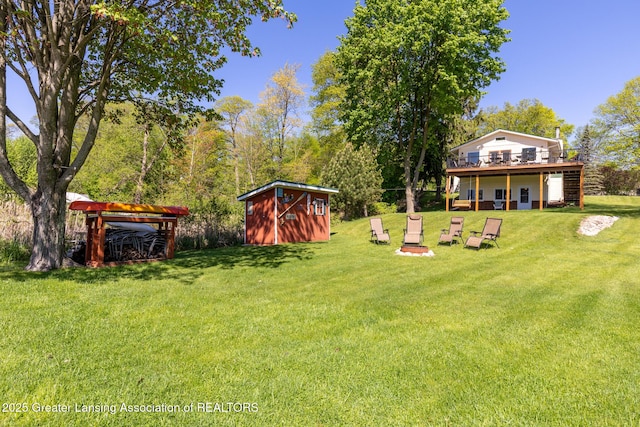 6391 Lakeshore Dr, Lakeview, MI 48850 - view of grassy yard with a storage shed, a wooden deck, and an outbuilding