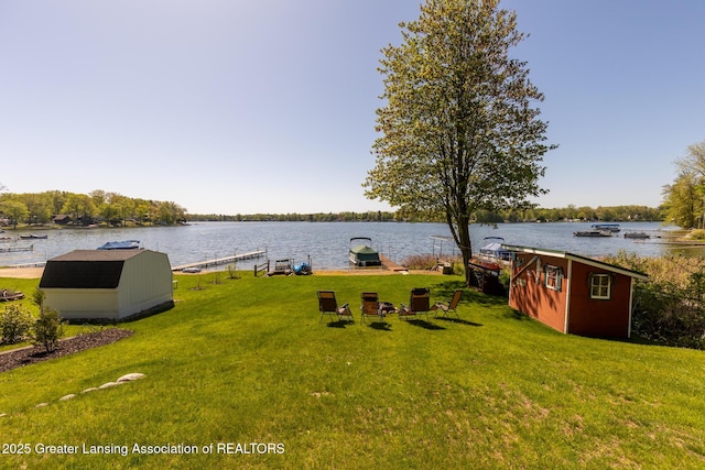 6391 Lakeshore Dr, Lakeview, MI 48850 - view of grassy yard featuring a shed, a water view, a dock, and an outdoor structure