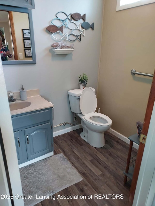 6391 Lakeshore Dr, Lakeview, MI 48850 - half bathroom with toilet, baseboards, vanity, and wood finished floors