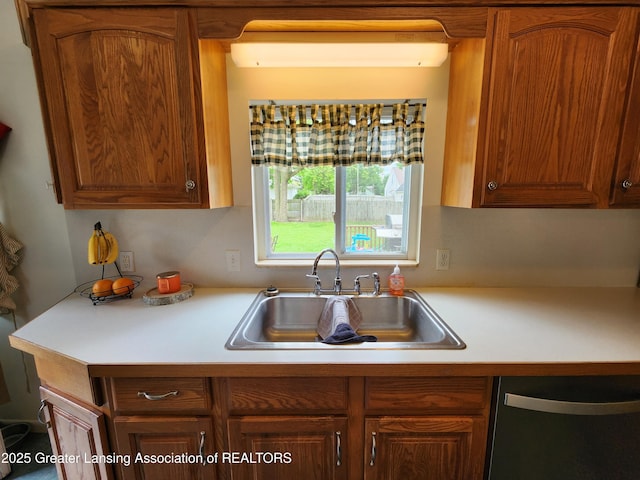 136 N Chestnut St, Owosso, MI 48867 - kitchen with dishwashing machine, a sink, light countertops, and brown cabinets