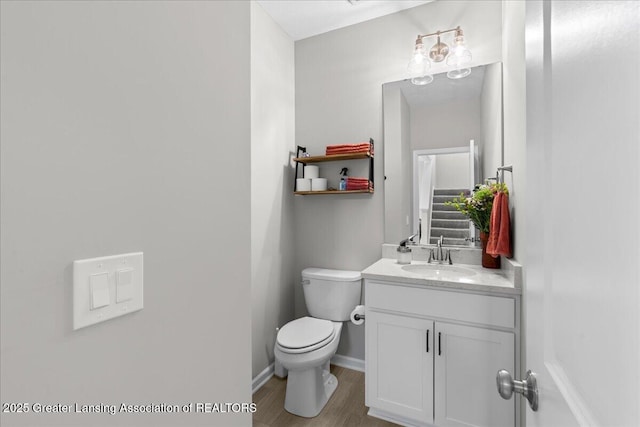 4150 Stillbrook Ln, Dewitt, MI 48820 - bathroom with toilet, vanity, baseboards, and wood finished floors