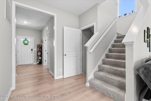 4150 Stillbrook Ln, Dewitt, MI 48820 - foyer entrance with light wood-type flooring, stairs, and baseboards