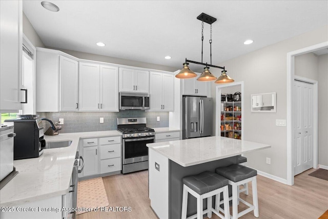 4150 Stillbrook Ln, Dewitt, MI 48820 - kitchen featuring stainless steel appliances, a sink, light wood-style floors, tasteful backsplash, and recessed lighting