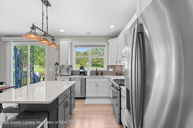 4150 Stillbrook Ln, Dewitt, MI 48820 - kitchen featuring stainless steel appliances, a sink, white cabinets, recessed lighting, and backsplash