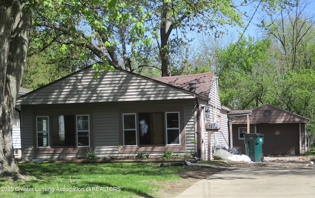 107 Cox Blvd, Lansing, MI 48910 - bungalow-style house with driveway, a front yard, and roof with shingles