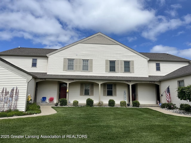 7436 Creekside Dr Unit 10, Lansing, MI 48917 - view of front of property with a front yard, a shingled roof, and covered porch