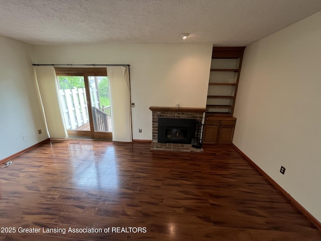 7436 Creekside Dr Unit 10, Lansing, MI 48917 - unfurnished living room featuring wood finished floors, baseboards, a textured ceiling, and a brick fireplace