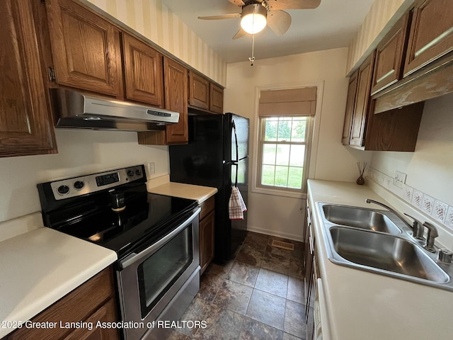7436 Creekside Dr Unit 10, Lansing, MI 48917 - kitchen with under cabinet range hood, stainless steel electric range oven, a sink, stone tile floors, and a ceiling fan