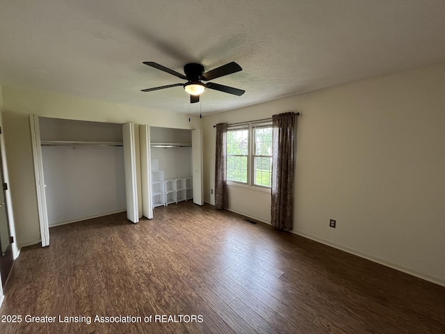 7436 Creekside Dr Unit 10, Lansing, MI 48917 - unfurnished bedroom with multiple closets, wood finished floors, a ceiling fan, and baseboards