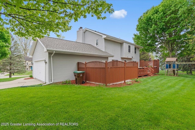 3720 Lott Ave, Holt, MI 48842 - back of property with a chimney, a garage, a playground, concrete driveway, and roof with shingles