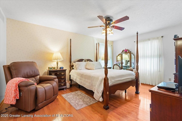 3720 Lott Ave, Holt, MI 48842 - bedroom featuring light wood finished floors, wallpapered walls, a textured ceiling, and ceiling fan