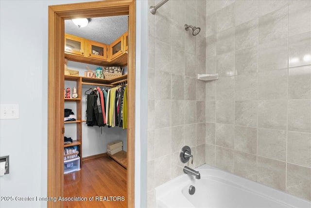 3720 Lott Ave, Holt, MI 48842 - full bath with wood finished floors, tub / shower combination, and a spacious closet