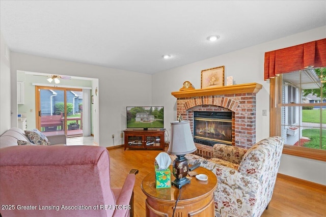 3720 Lott Ave, Holt, MI 48842 - living room featuring wood finished floors, a brick fireplace, and baseboards