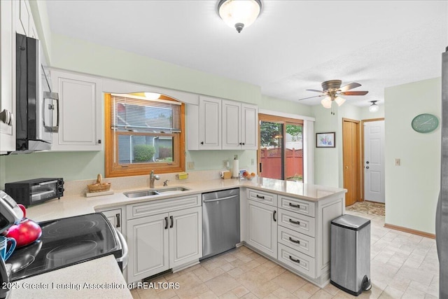 3720 Lott Ave, Holt, MI 48842 - kitchen featuring appliances with stainless steel finishes, a sink, a peninsula, and light countertops
