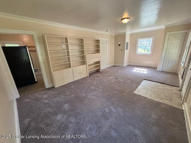 704 Mckim Ave, Lansing, MI 48910 - unfurnished bedroom with crown molding, carpet, and freestanding refrigerator