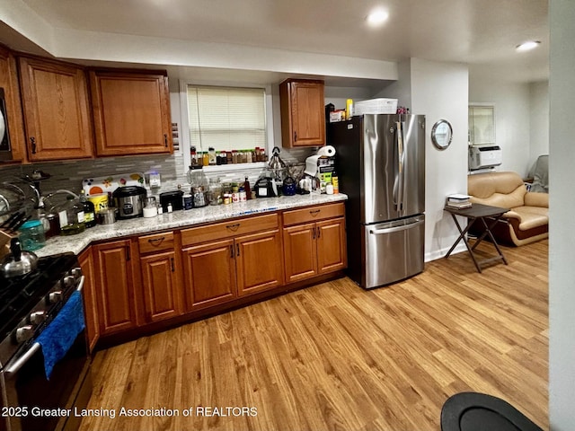 1916 W Jolly Rd, Lansing, MI 48910 - kitchen featuring appliances with stainless steel finishes, brown cabinetry, light wood finished floors, backsplash, and recessed lighting