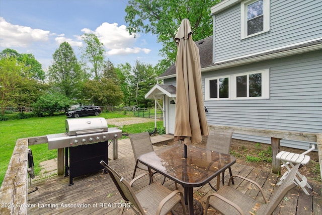 5104 Old Lansing Rd, Lansing, MI 48917 - wooden deck featuring outdoor dining area, grilling area, and view of wooded area
