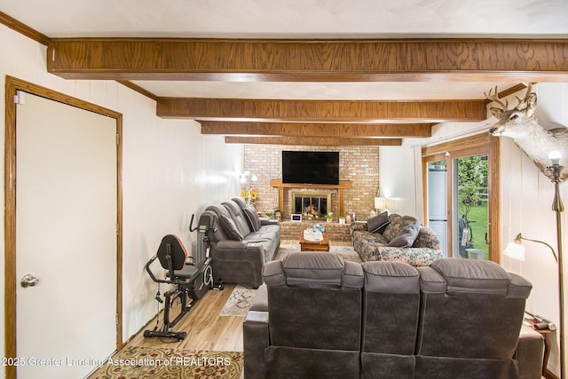 3733 Colchester Rd, Lansing, MI 48906 - living room featuring wood finished floors, beam ceiling, and a brick fireplace