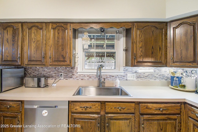 3733 Colchester Rd, Lansing, MI 48906 - kitchen featuring a sink, dishwasher, light countertops, and decorative backsplash