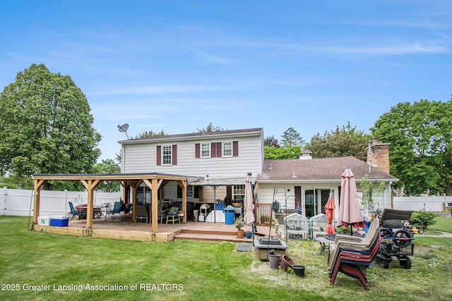 3733 Colchester Rd, Lansing, MI 48906 - rear view of house with a wooden deck, a gazebo, a fire pit, and a chimney