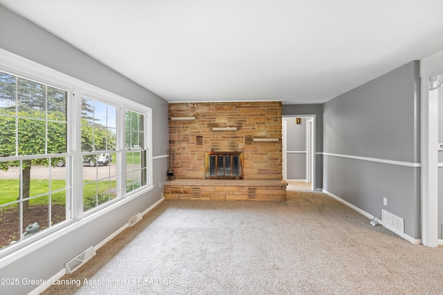 1111 Battle Creek Rd, Charlotte, MI 48813 - unfurnished living room featuring carpet floors, a stone fireplace, and baseboards