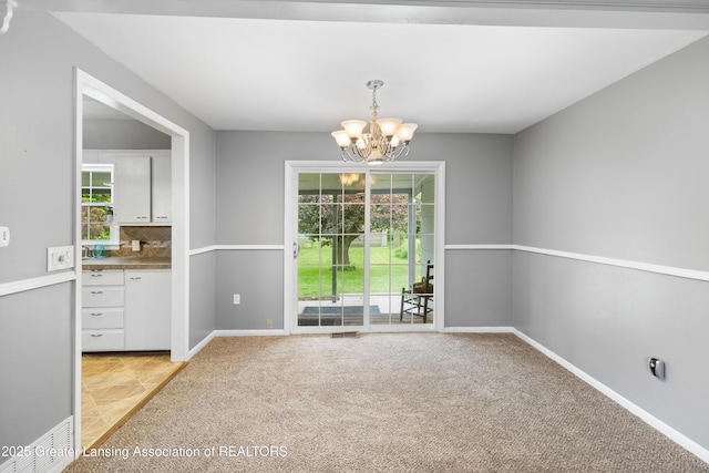 1111 Battle Creek Rd, Charlotte, MI 48813 - unfurnished dining area featuring a chandelier, light colored carpet, and baseboards