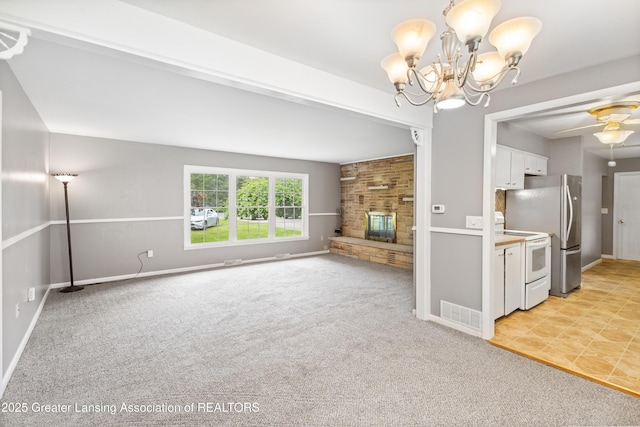 1111 Battle Creek Rd, Charlotte, MI 48813 - unfurnished living room featuring light carpet, a chandelier, a ceiling fan, a fireplace, and baseboards