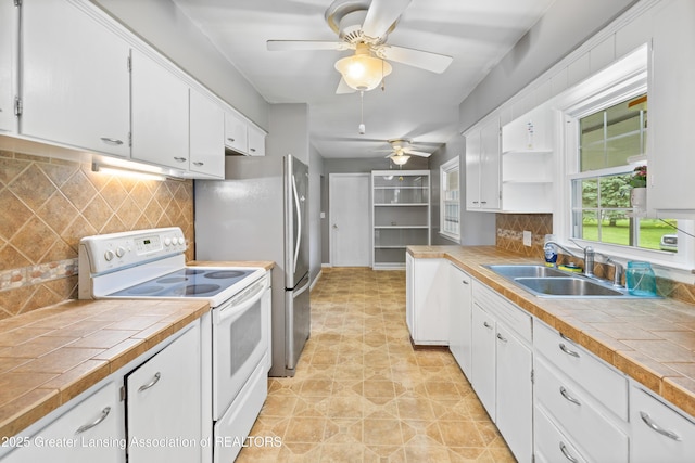 1111 Battle Creek Rd, Charlotte, MI 48813 - kitchen with white range with electric stovetop, a sink, ceiling fan, white cabinets, and tasteful backsplash