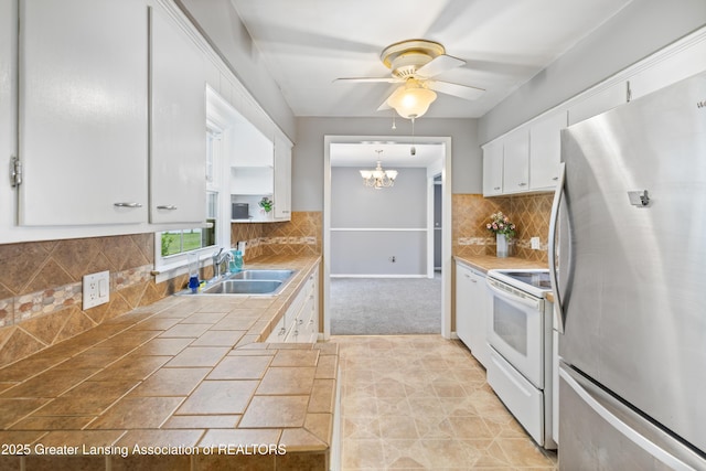 1111 Battle Creek Rd, Charlotte, MI 48813 - kitchen featuring freestanding refrigerator, white electric stove, a sink, tile countertops, and white cabinetry