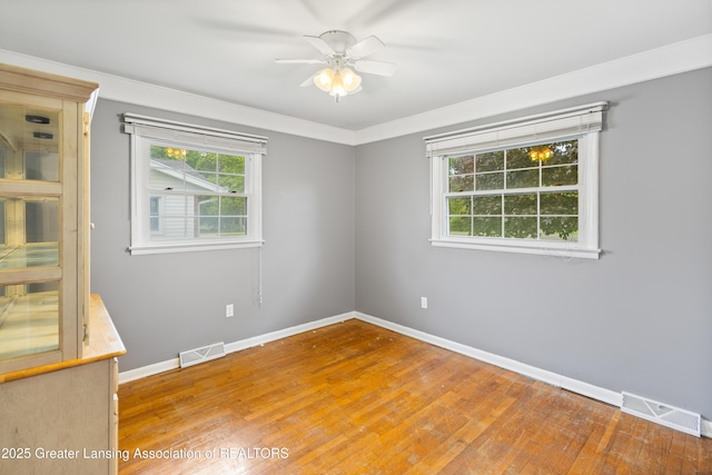 1111 Battle Creek Rd, Charlotte, MI 48813 - empty room featuring wood-type flooring, plenty of natural light, and baseboards