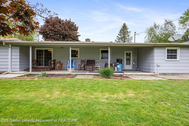 1111 Battle Creek Rd, Charlotte, MI 48813 - back of house with covered porch, a yard, and a chimney