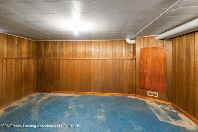1111 Battle Creek Rd, Charlotte, MI 48813 - finished below grade area featuring carpet flooring, wooden walls, and baseboards