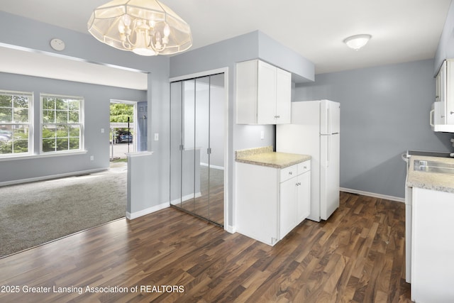6215 Beechfield Dr, Lansing, MI 48911 - kitchen featuring freestanding refrigerator, white cabinetry, dark wood-style flooring, and a chandelier