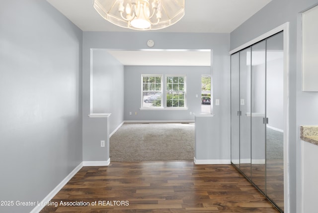 6215 Beechfield Dr, Lansing, MI 48911 - corridor featuring a chandelier, wood finished floors, and baseboards